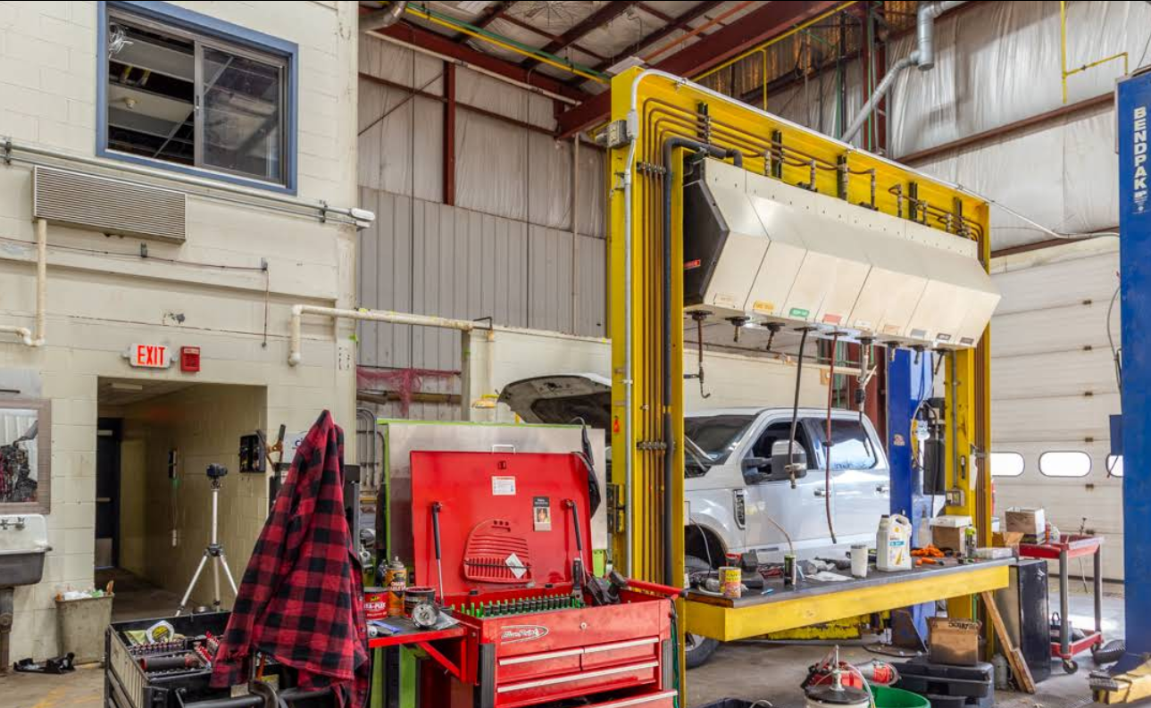 A truck is sitting on a lift in a garage.