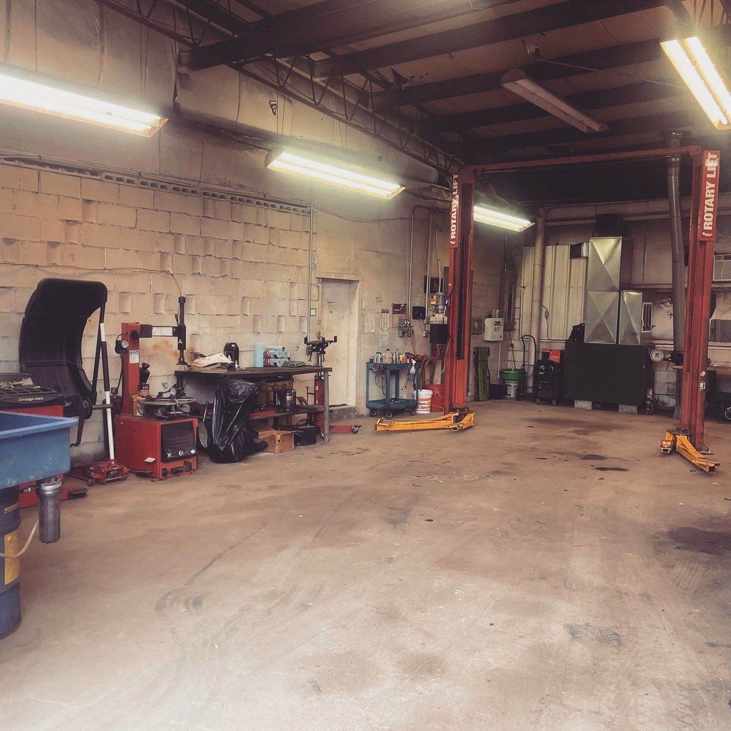 An empty garage with a lift that says ' chevrolet ' on it