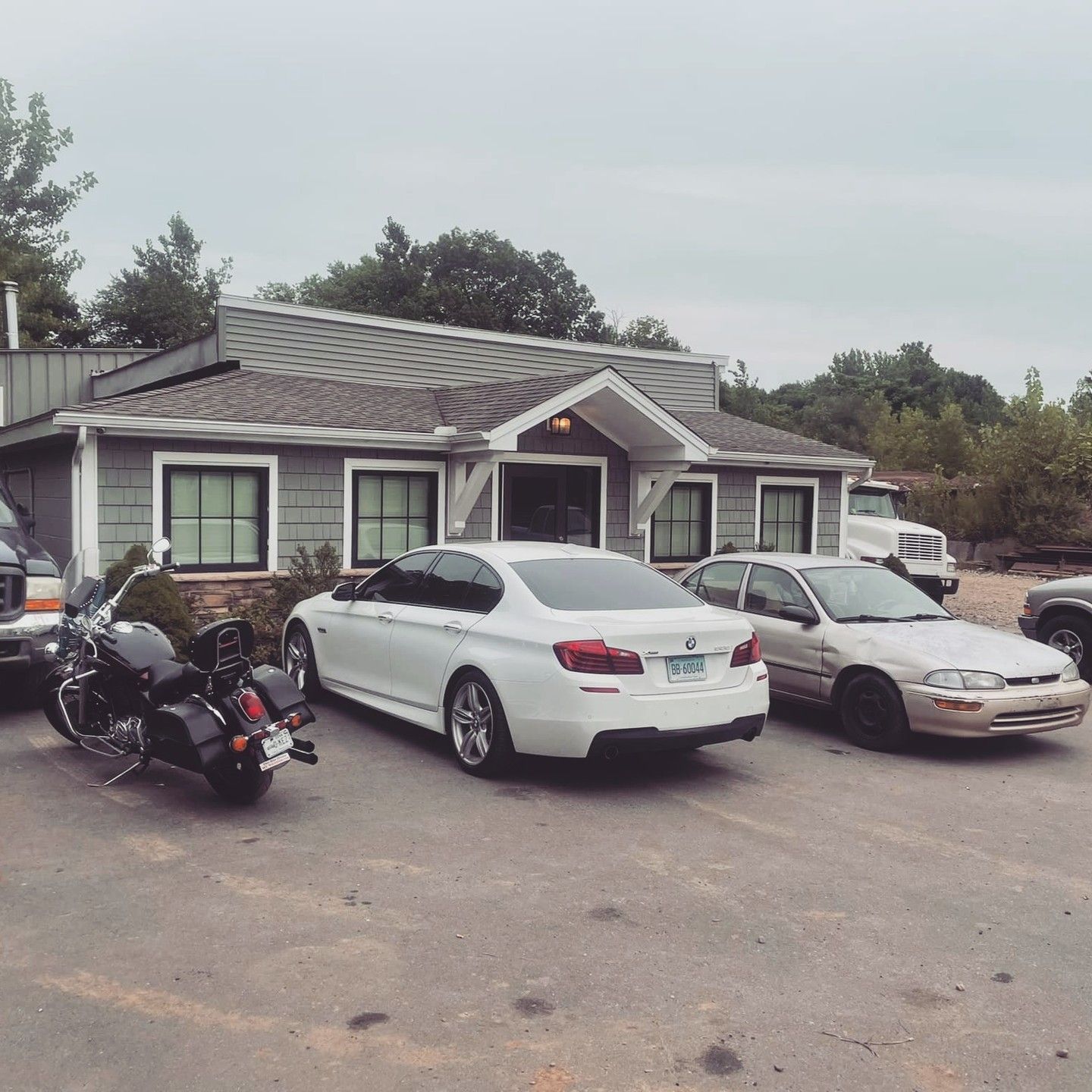 A row of cars are parked in front of a building
