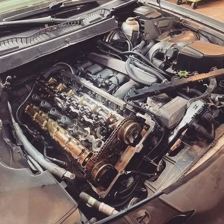 A close up of a car engine with the hood open