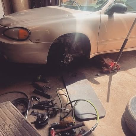 A white car is being worked on in a garage
