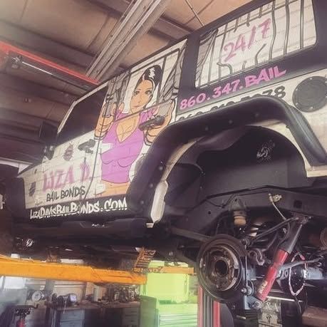 A car is sitting on a lift in a garage.