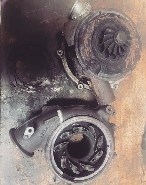 Two turbochargers are sitting on a wooden table