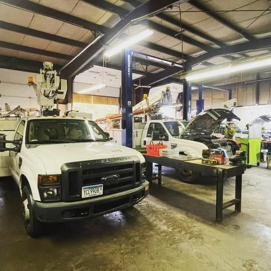 A white ford truck with a license plate that says ' gn48 ' is parked in a garage