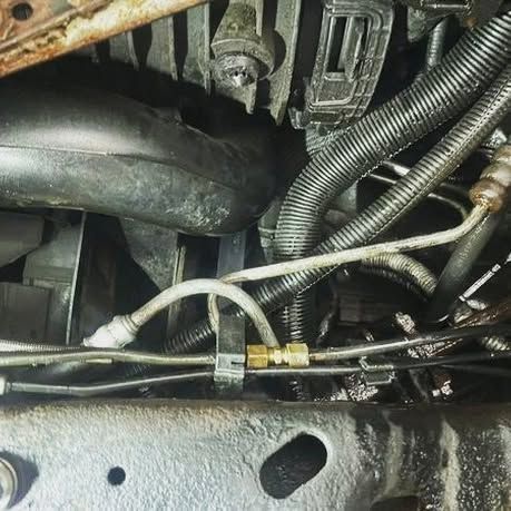 A close up of a car engine with a lot of hose attached to it.