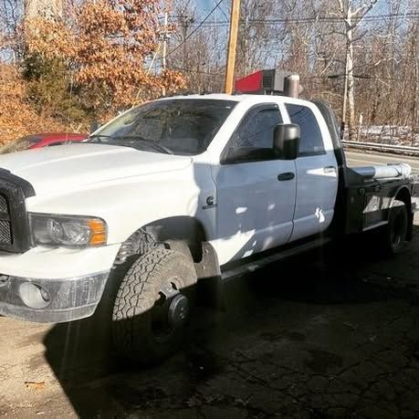 A white tow truck is parked on the side of the road.