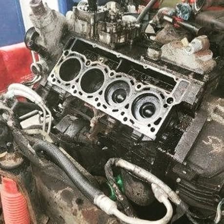 A close up of a car engine being worked on.