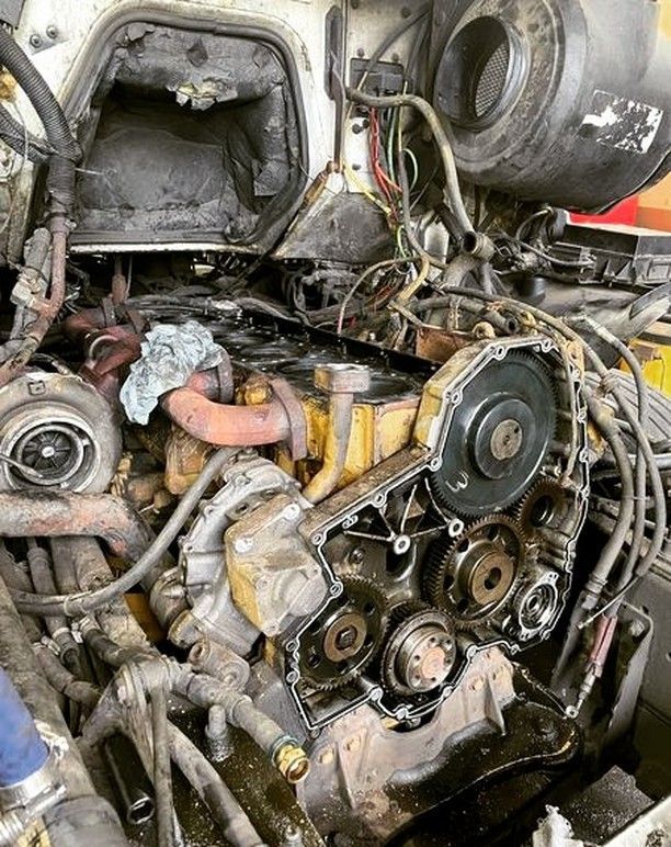 The engine of a truck is being repaired in a garage.