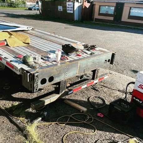 A flatbed truck is sitting on the side of the road.