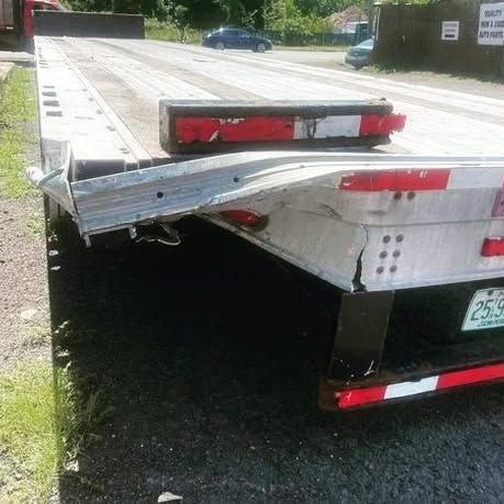 A flatbed tow truck is parked on the side of the road.