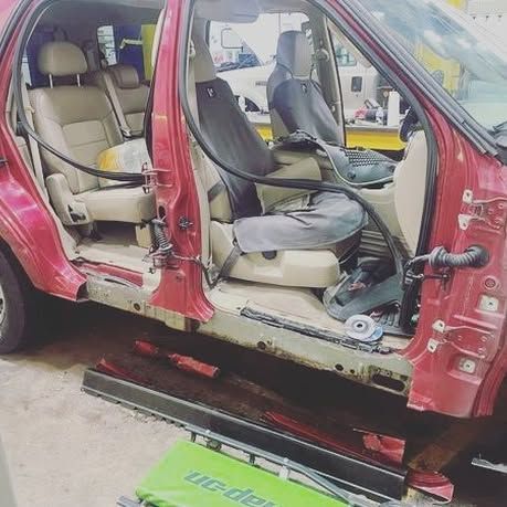 A red car is sitting on a green table in a garage.