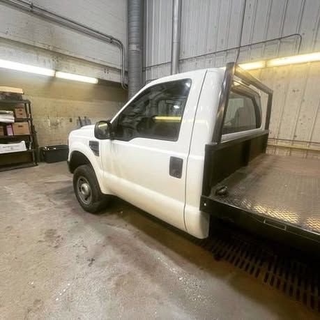A white tow truck is parked in a garage.