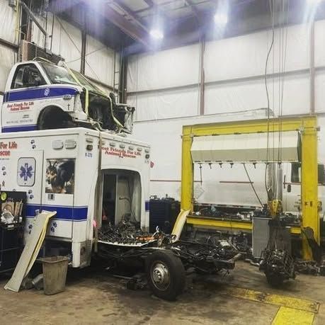 An ambulance is being repaired in a garage.