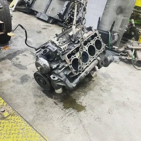 A large engine is sitting on the ground in a garage.