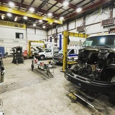A truck is sitting on a lift in a garage.