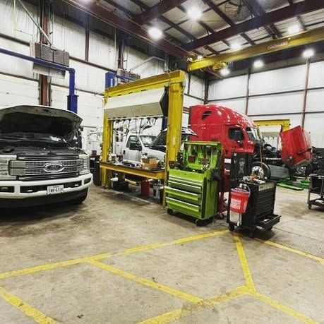 A ford truck is being worked on in a garage.
