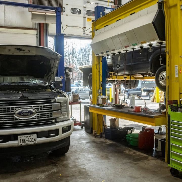 A ford truck with the hood up in a garage