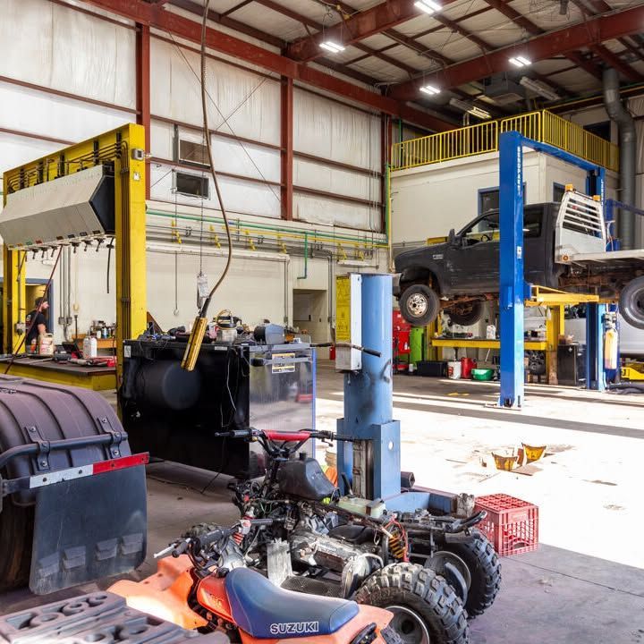 A suzuki atv is parked in a garage