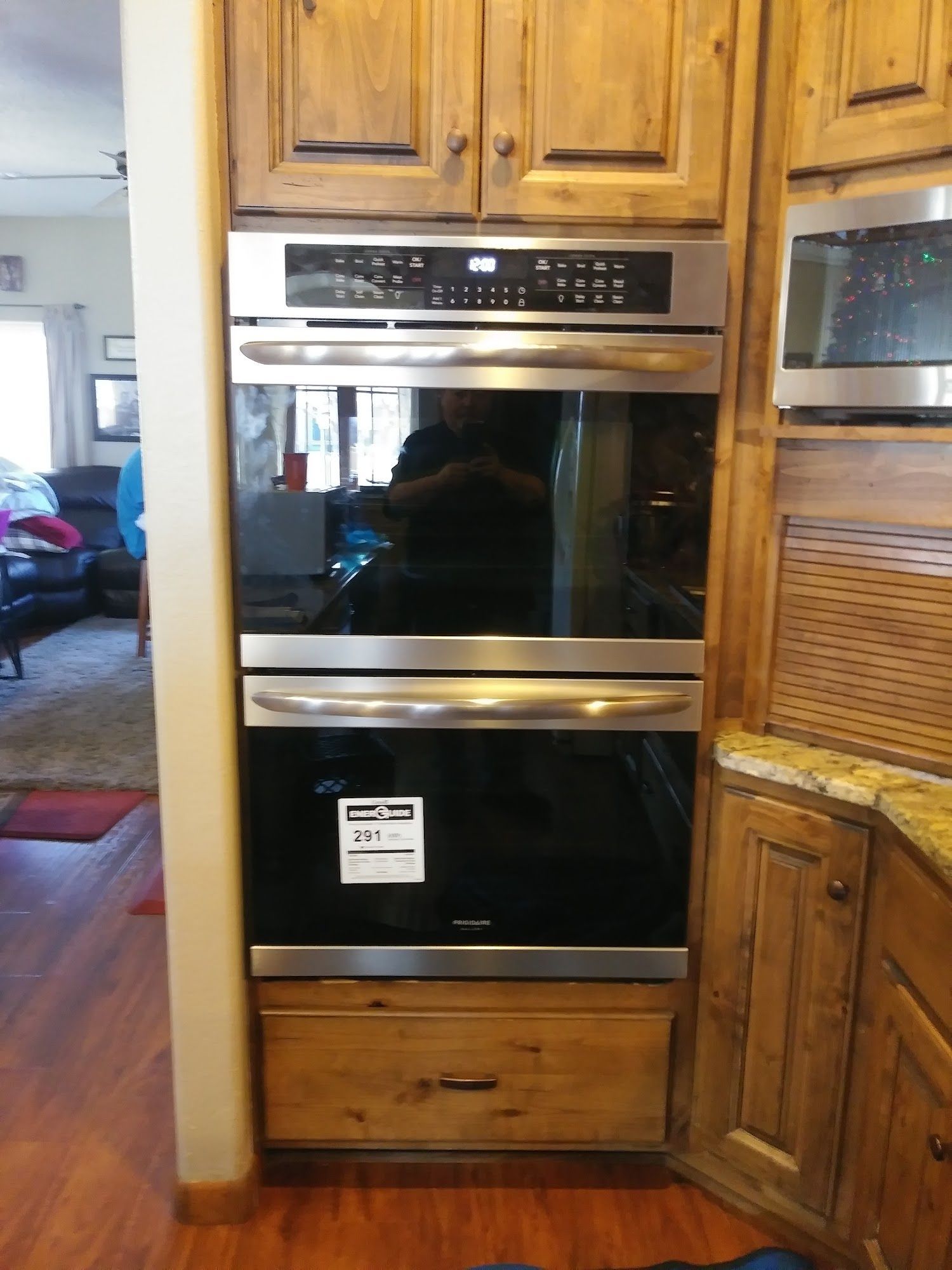 Built-in double oven in wooden cabinets. Bottom drawer below. Stainless steel appliances.