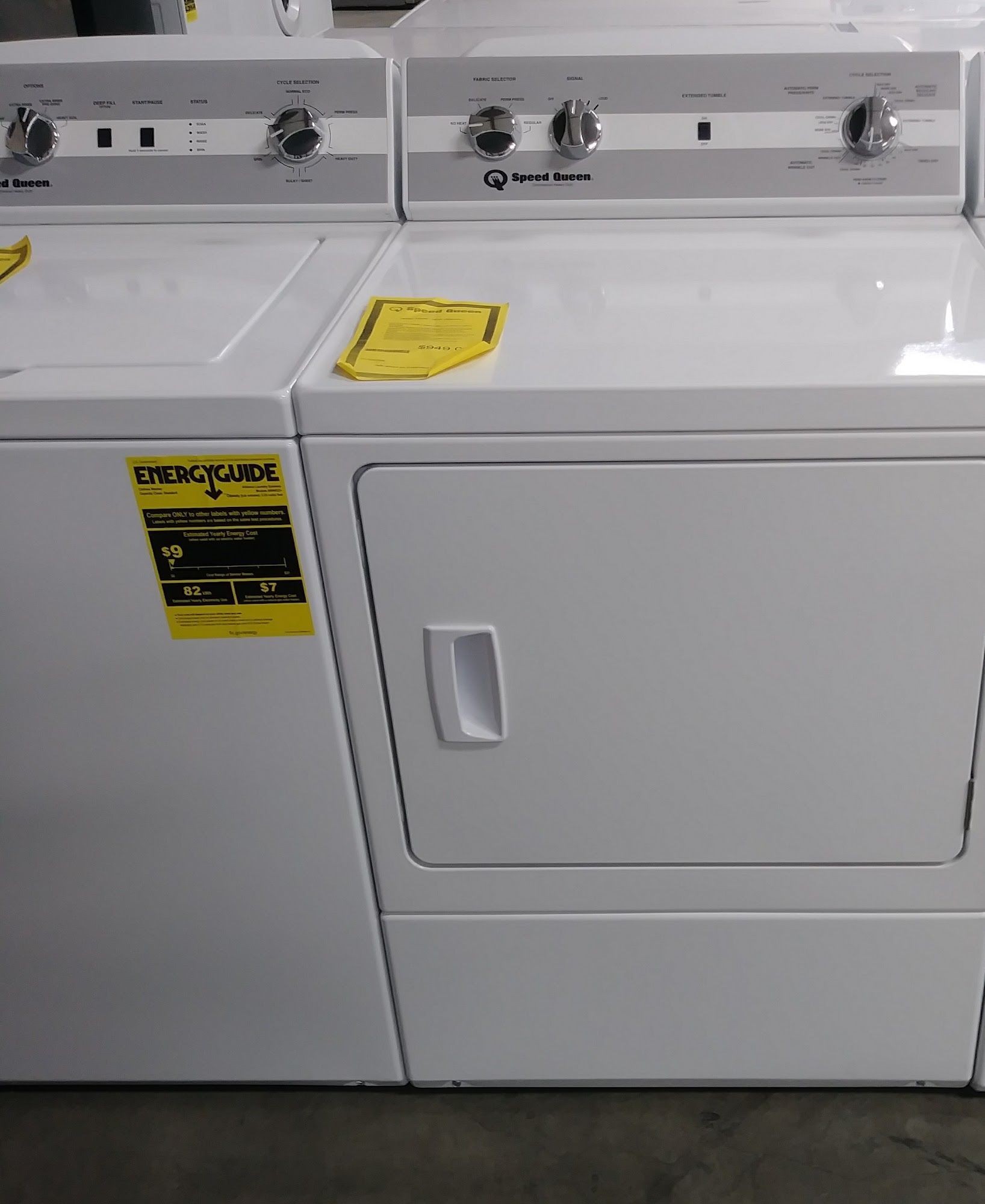 White washing machine and dryer set with control panels and a yellow energy label.