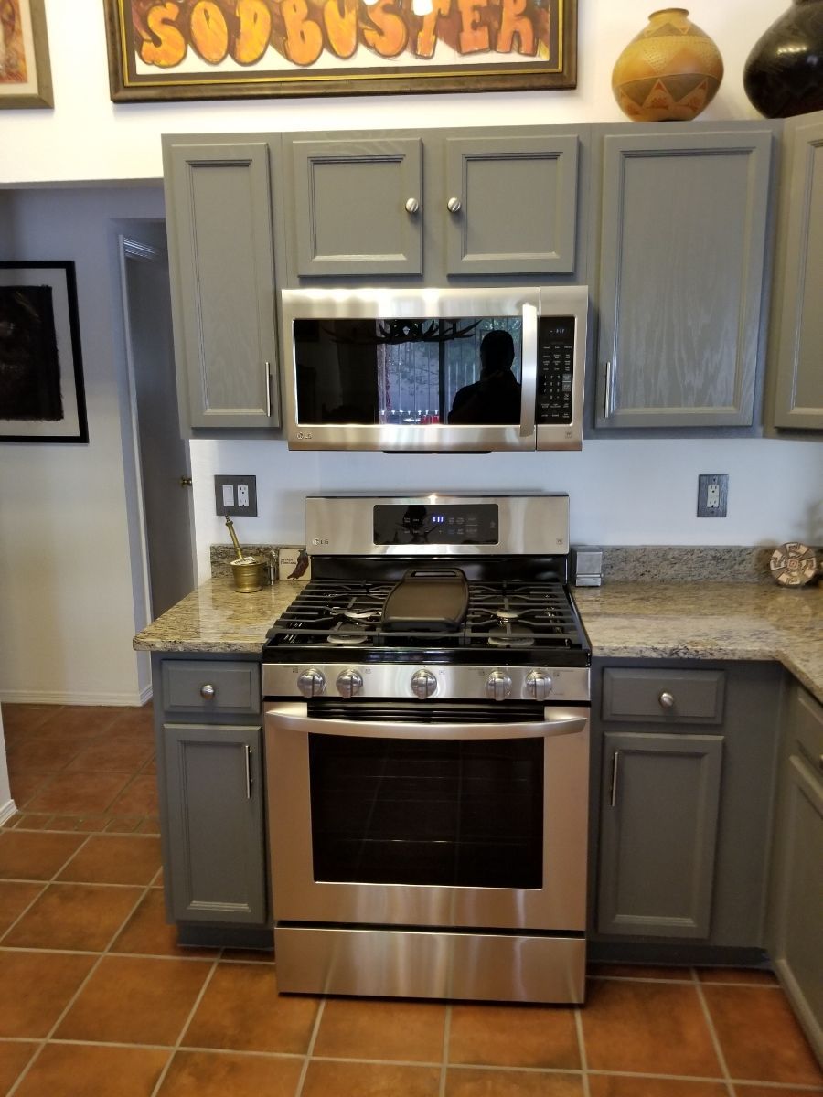 Kitchen with gray cabinets, stainless steel appliances, and granite countertops.
