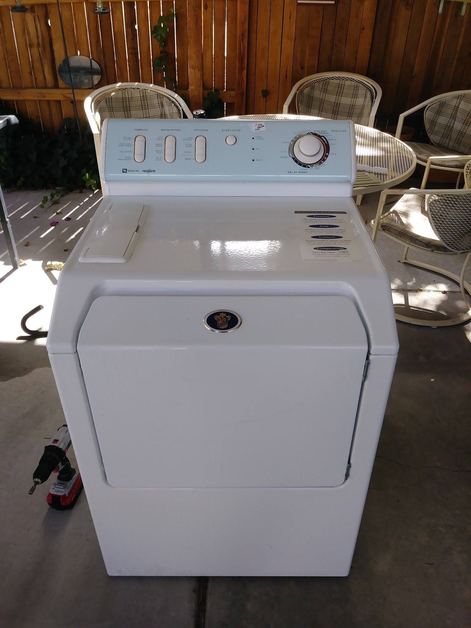 White electric dryer with control panel, in an outdoor setting.