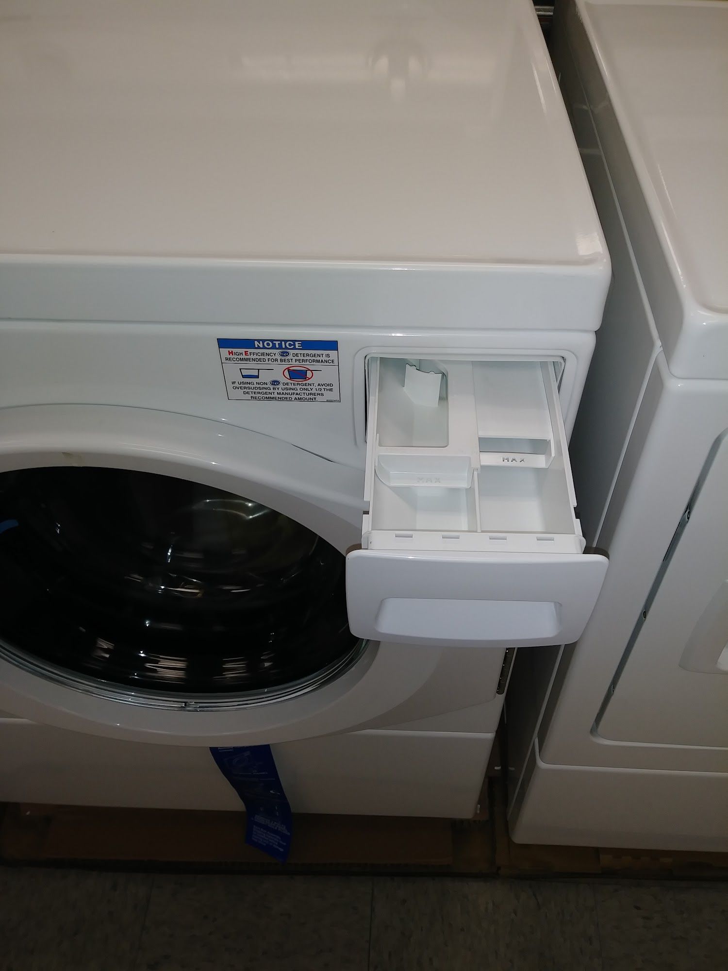 White washing machine with opened detergent dispenser drawer.