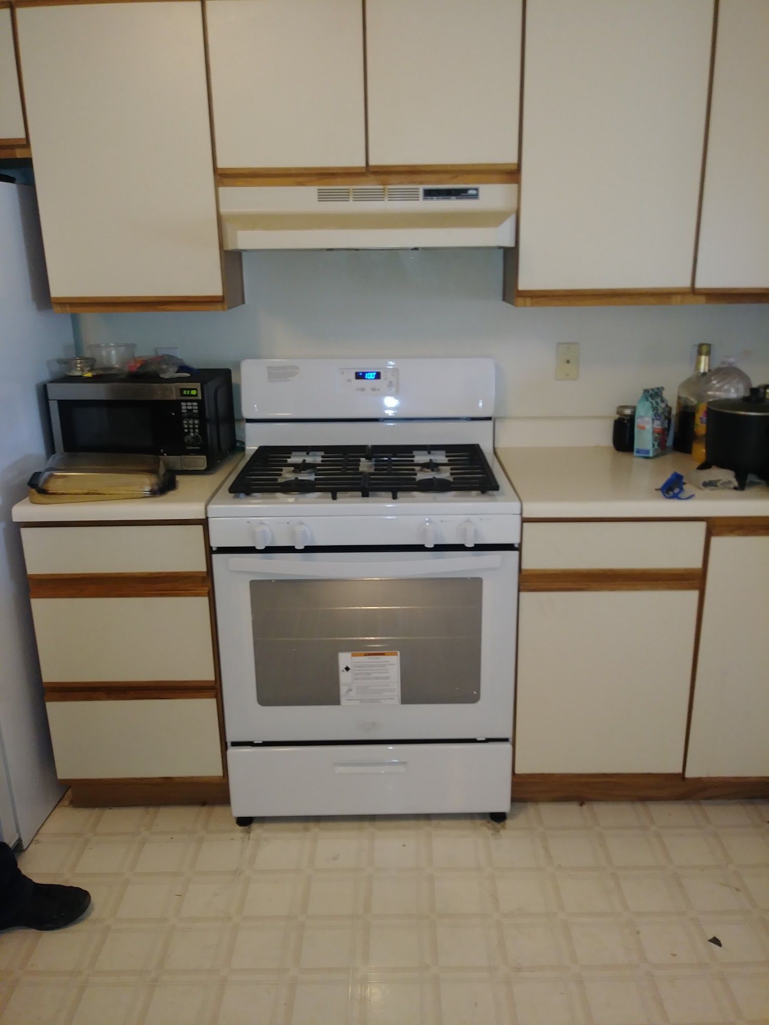 White kitchen with a gas stove, cabinets, and a countertop.