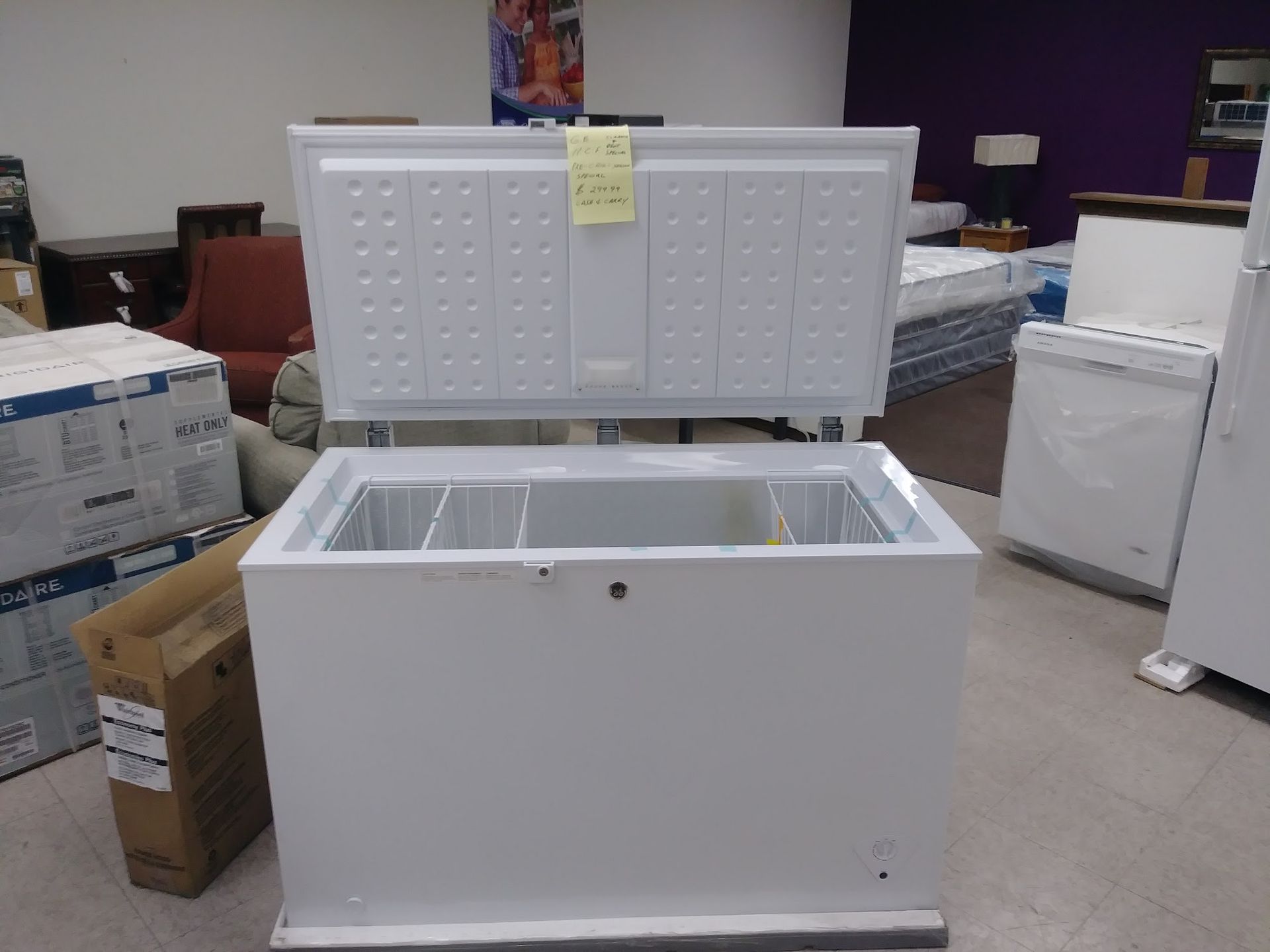 White chest freezer with lid open, in a retail setting.