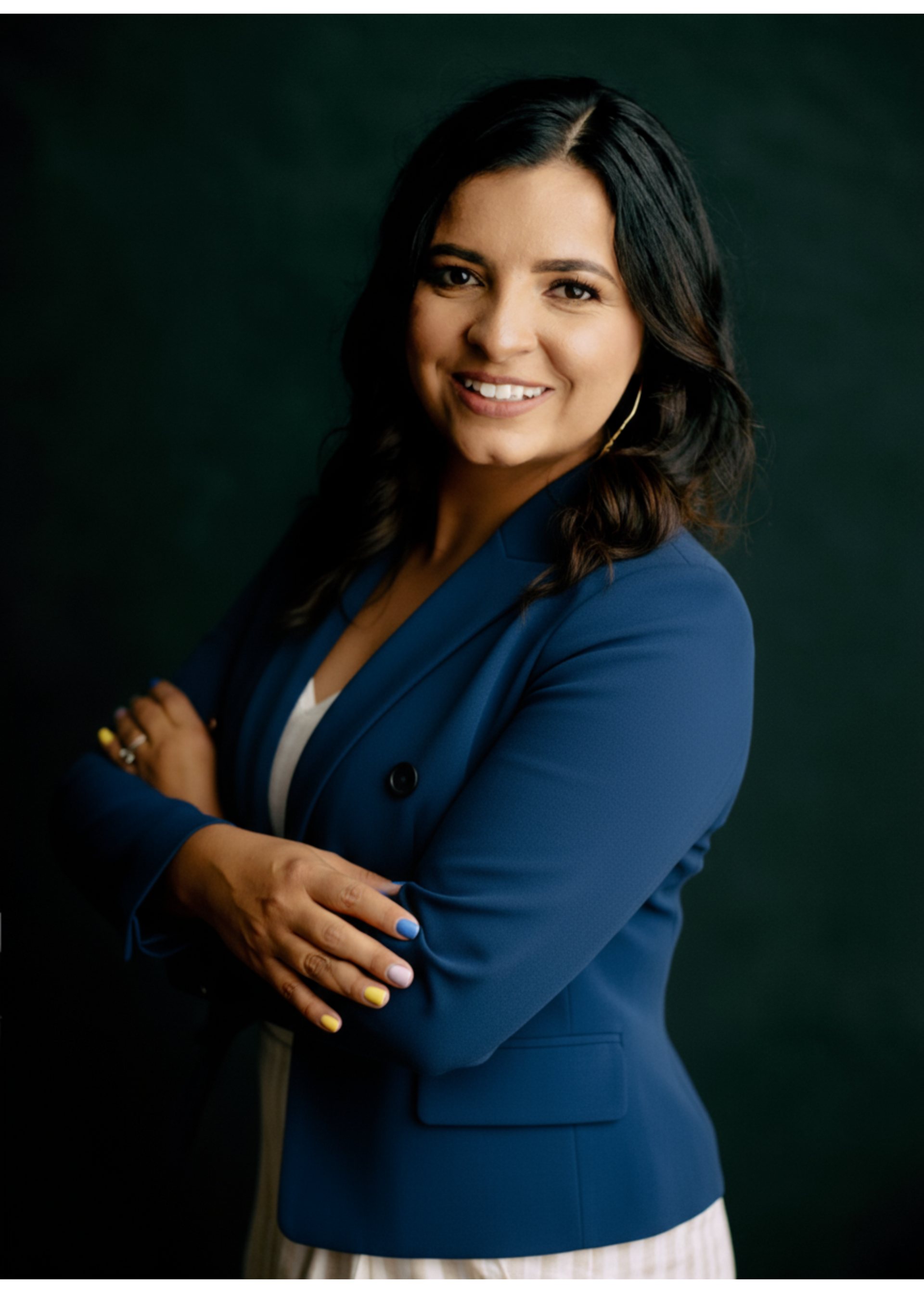 A man in a suit and vest is standing in front of a white background.