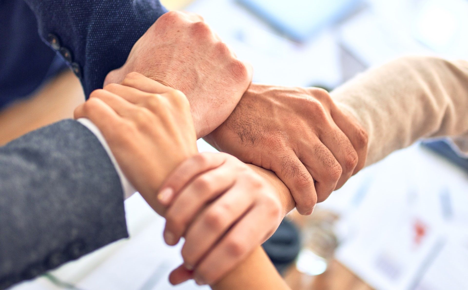 A group of people are putting their hands together.