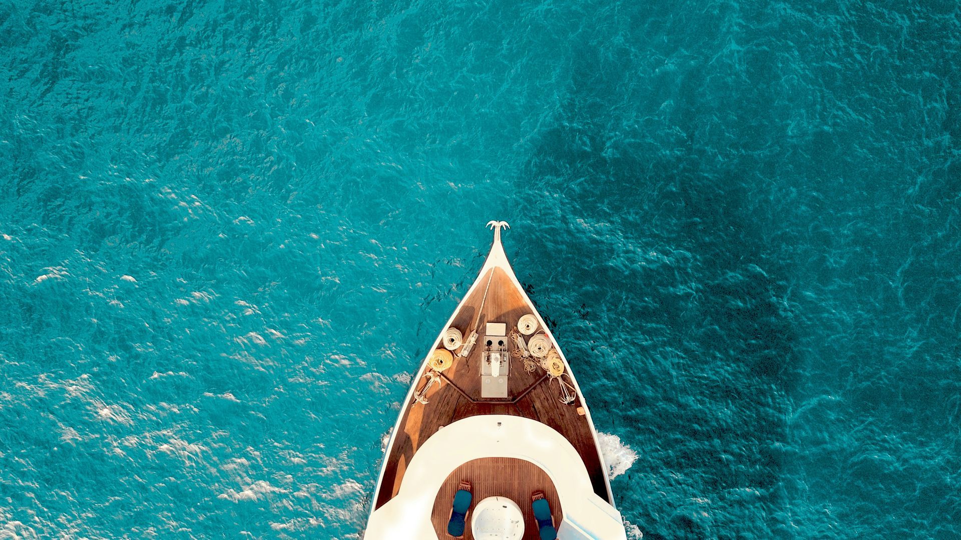 An aerial view of a yacht in the ocean.