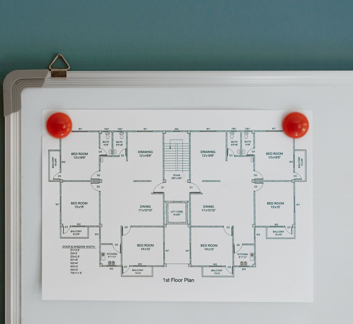Whiteboard with architectural plans held up by board magnets