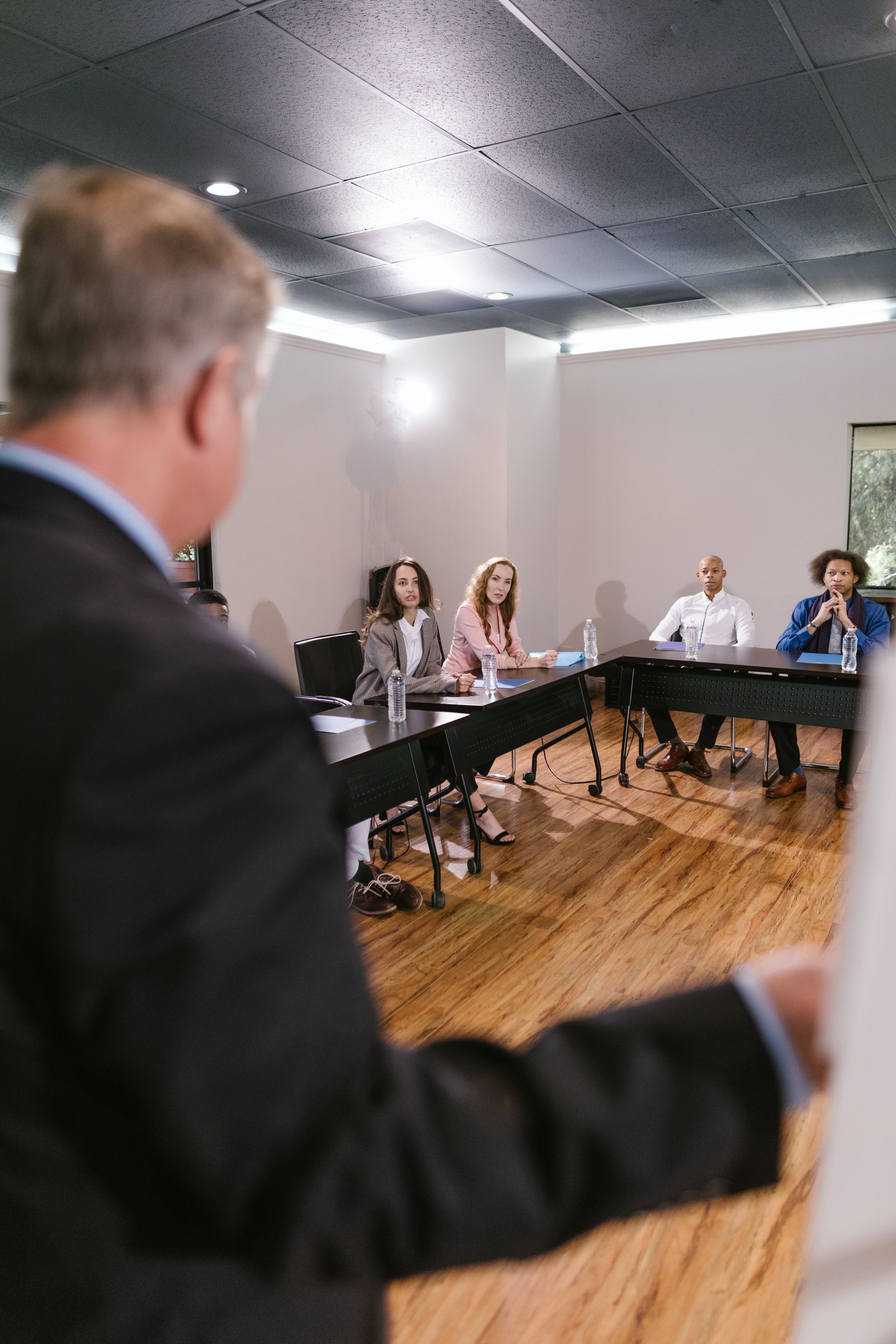 Man presenting to a room of seated colleagues