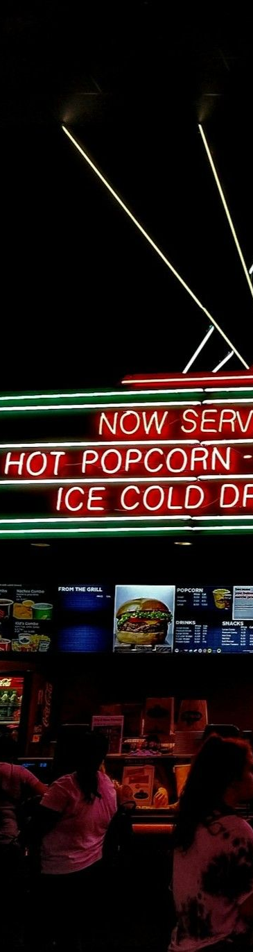 Film set with crew, monitors, lights, and a camera crane. Interior, low light.