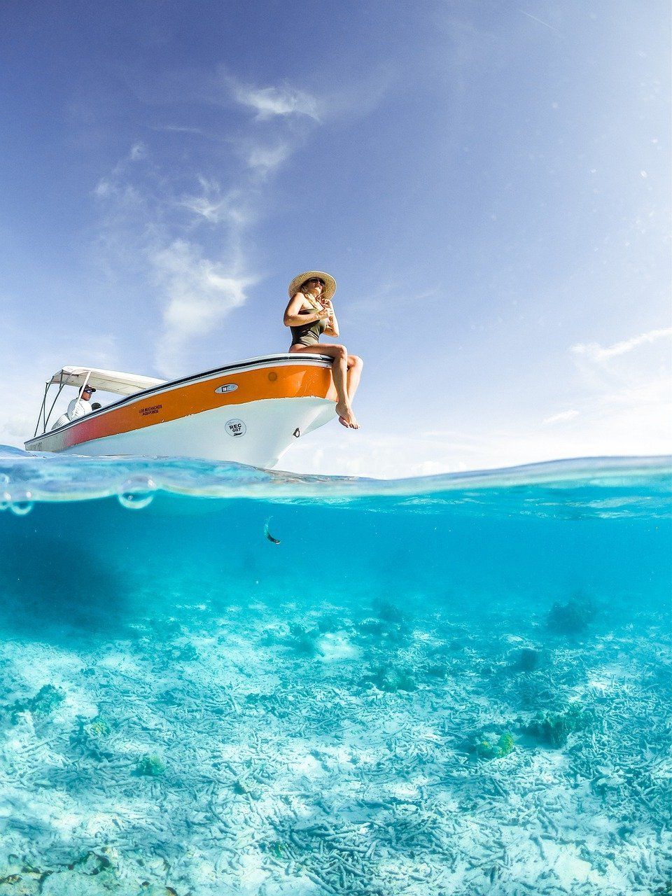 A woman is sitting on a boat in the ocean.