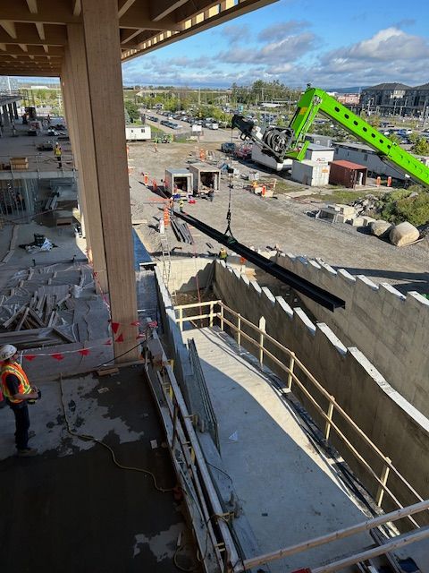 Un chantier de construction avec une grue verte et des escaliers en construction.