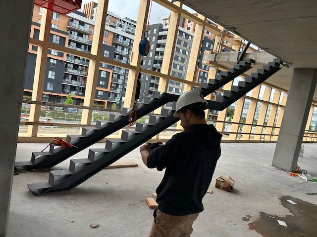 Un homme portant un casque de sécurité transporte un escalier