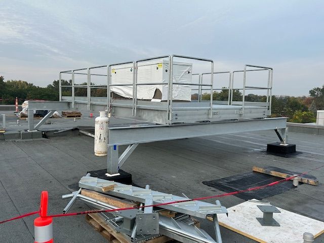 Une plate-forme métallique au sommet d'un toit avec une bouteille dessus