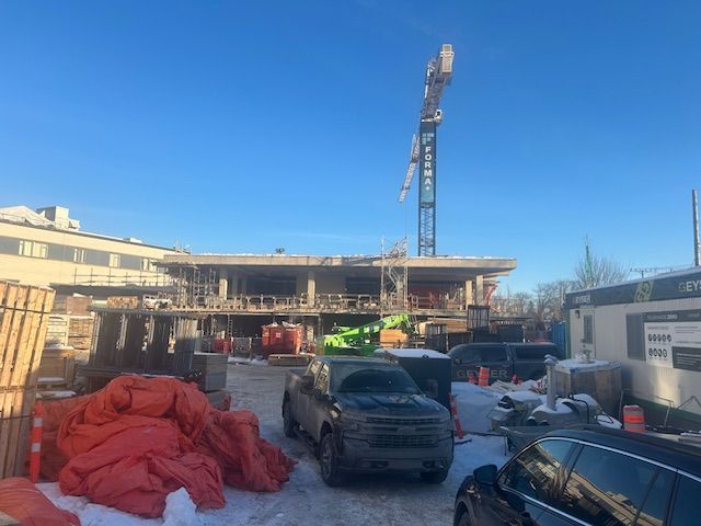 Une voiture est garée devant un immeuble en construction.