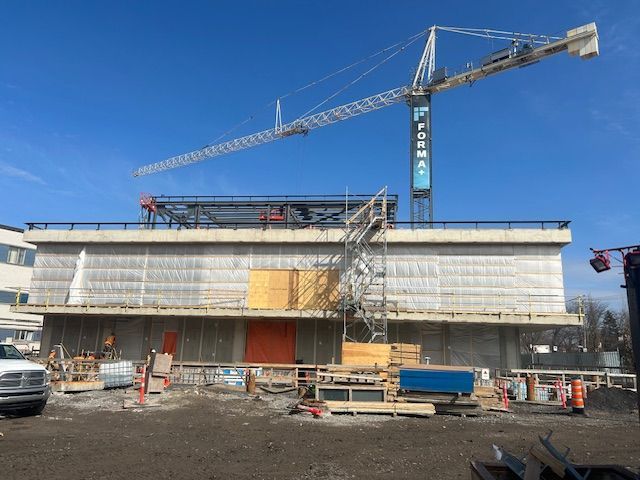 Un grand bâtiment en construction avec une grue au-dessus