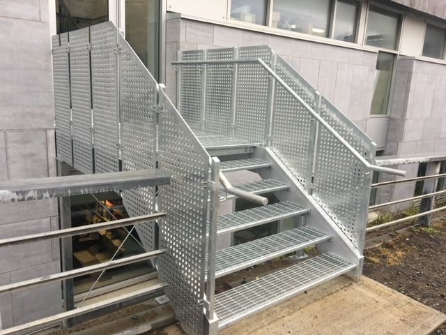 Un escalier métallique menant à un bâtiment.