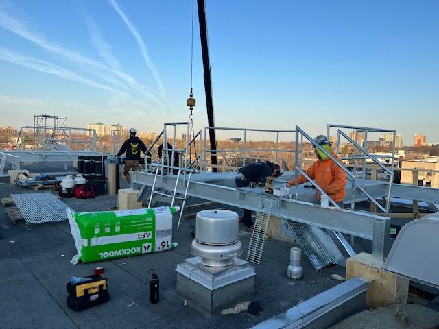 Un groupe d ouvriers du bâtiment travaille sur le toit d un immeuble.