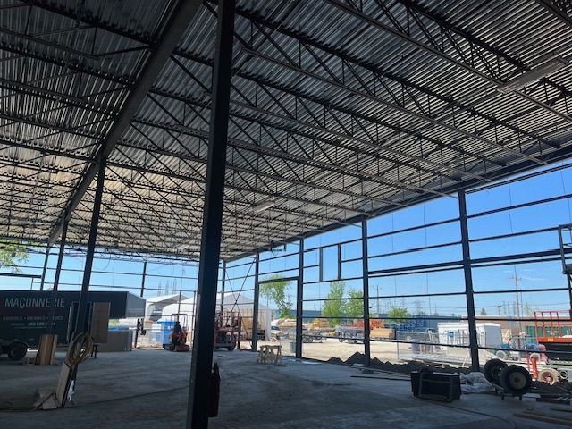 Une grande structure métallique avec un toit en cours de construction