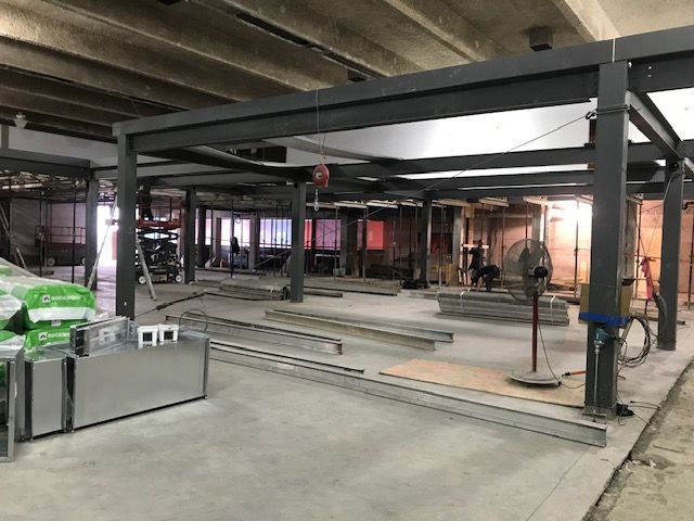 Une grande pièce avec beaucoup de charpentes métalliques et un ventilateur.