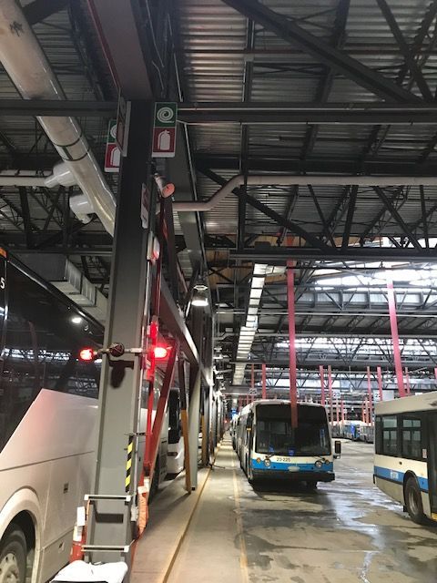 Une rangée de bus est garée dans un entrepôt