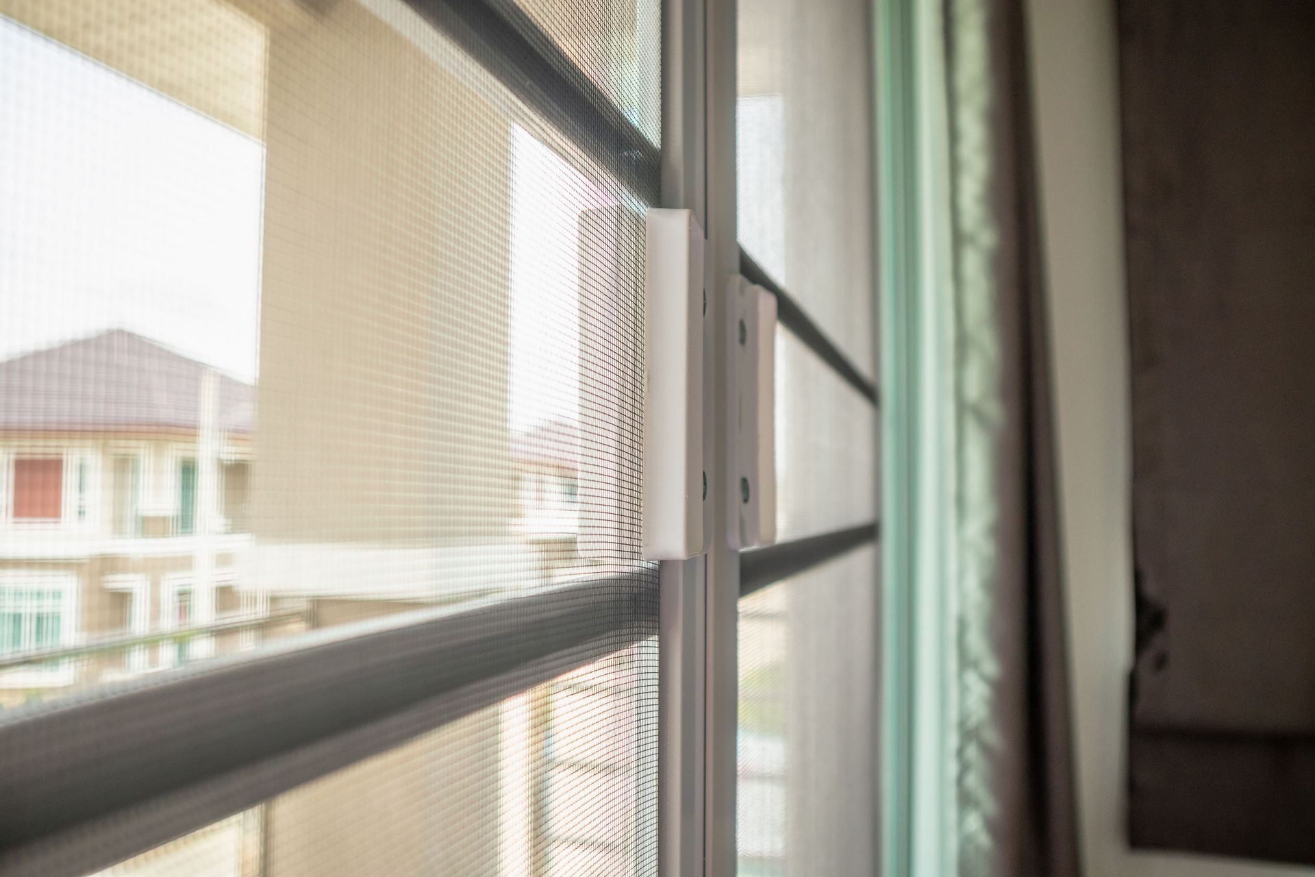 a close up of a sliding glass door with a mosquito net on it