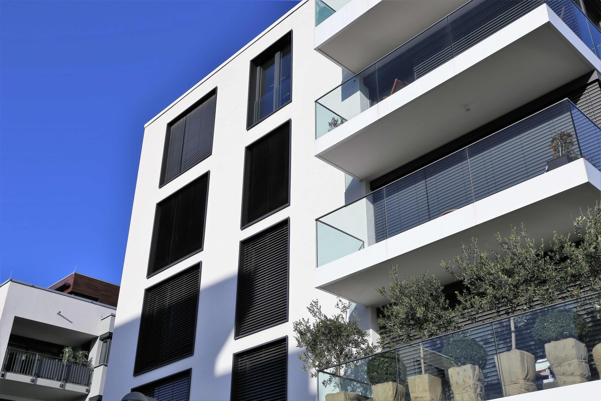 a white building with balconies and a blue sky in the background