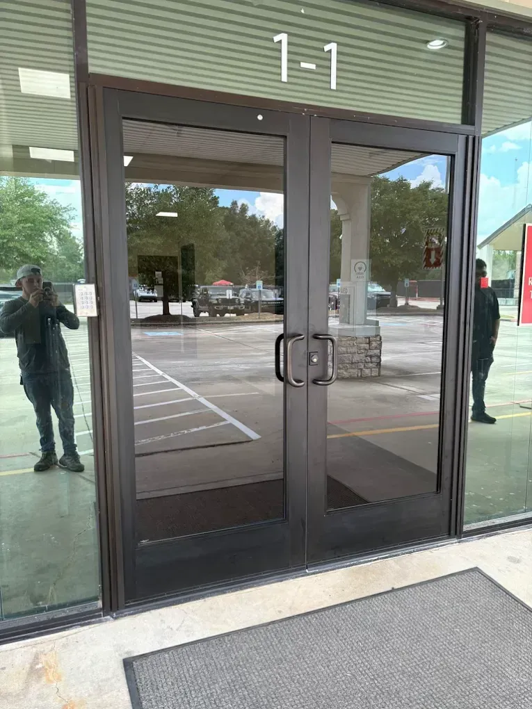 A ground-level entrance with glass double doors marked 