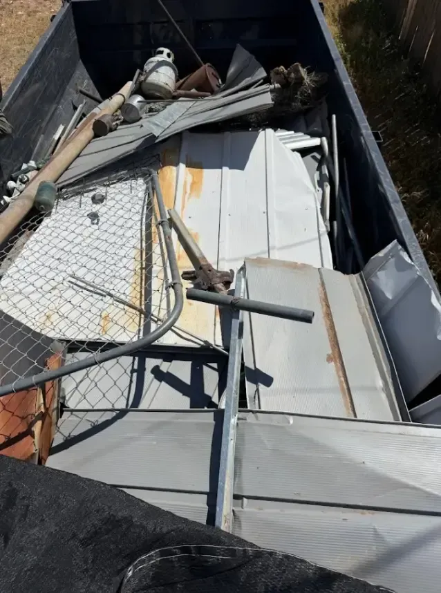 A truck bed filled with scrap metal and tools.